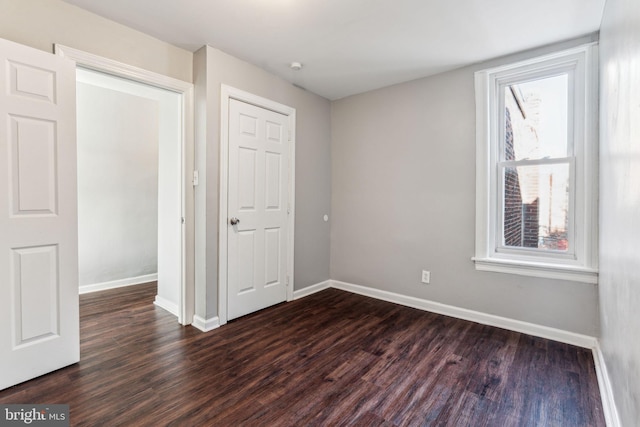 unfurnished room with dark wood-type flooring