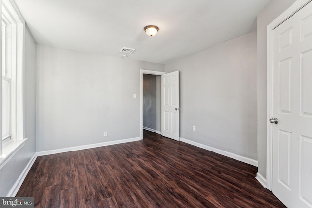 unfurnished room featuring dark wood-type flooring