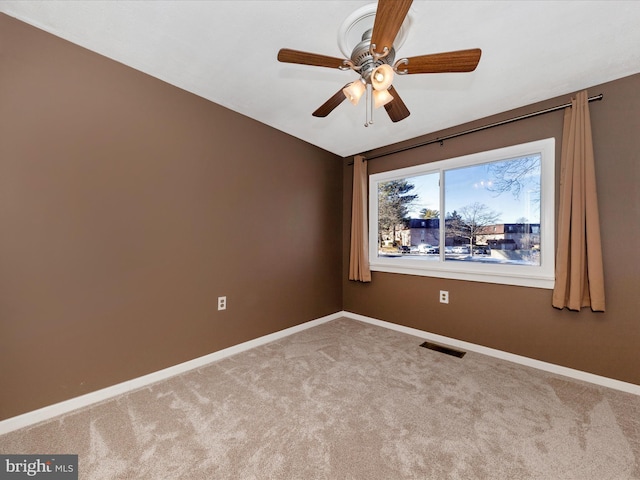 spare room featuring light carpet and ceiling fan