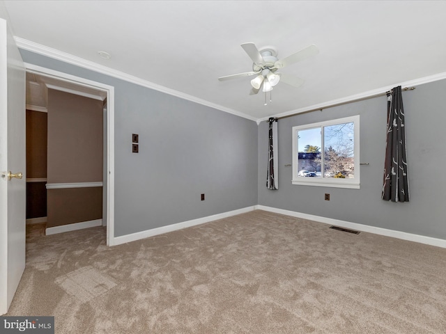 carpeted empty room featuring crown molding and ceiling fan