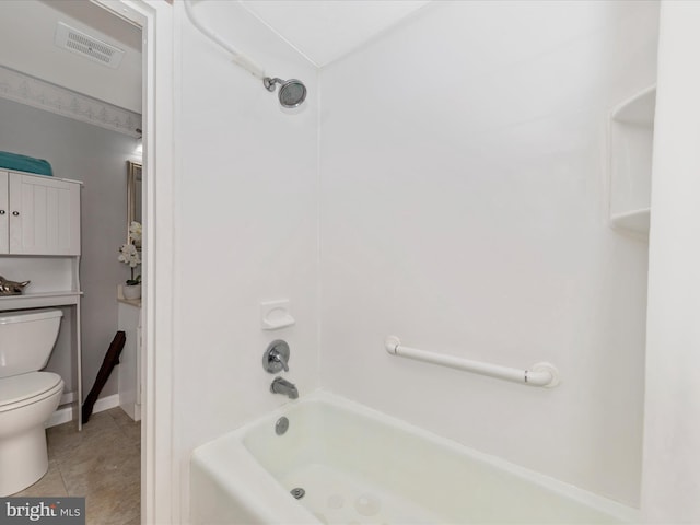 bathroom with tile patterned floors, bathing tub / shower combination, and toilet