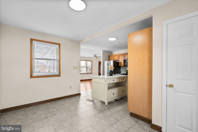 kitchen featuring stainless steel fridge, ceiling fan, tasteful backsplash, a kitchen island, and light brown cabinetry