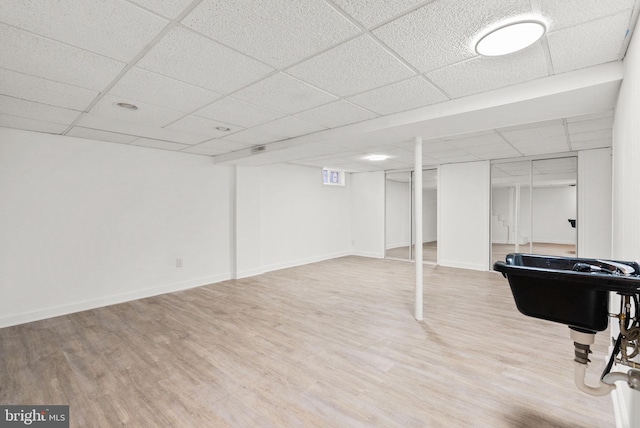 basement featuring a drop ceiling and wood-type flooring