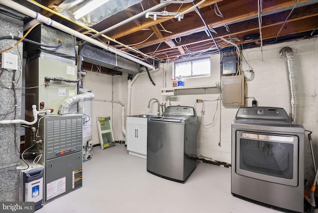 laundry area with sink, electric panel, washing machine and dryer, and heating unit