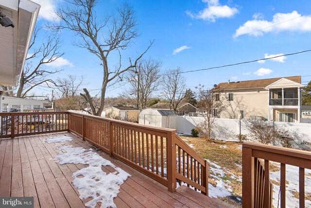 snow covered deck featuring a storage unit