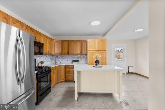 kitchen with a breakfast bar, sink, black appliances, a kitchen island, and backsplash