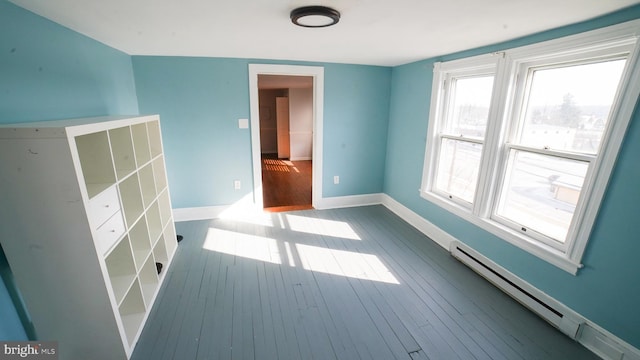 empty room featuring hardwood / wood-style floors and a baseboard radiator