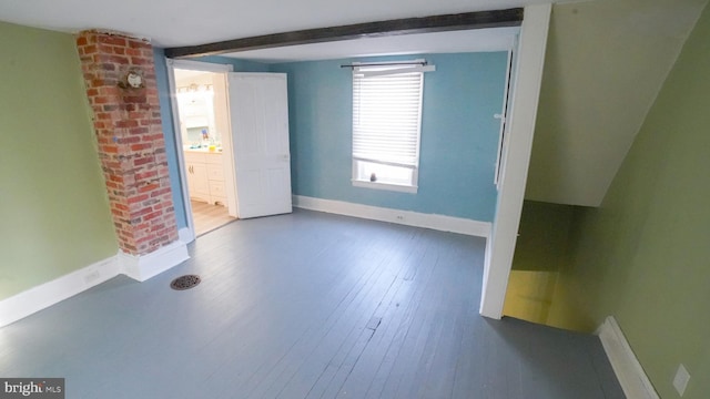 spare room with hardwood / wood-style floors and beam ceiling