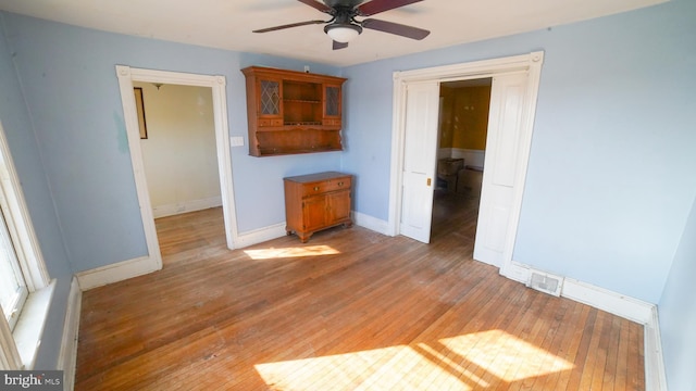 unfurnished living room featuring hardwood / wood-style flooring and ceiling fan