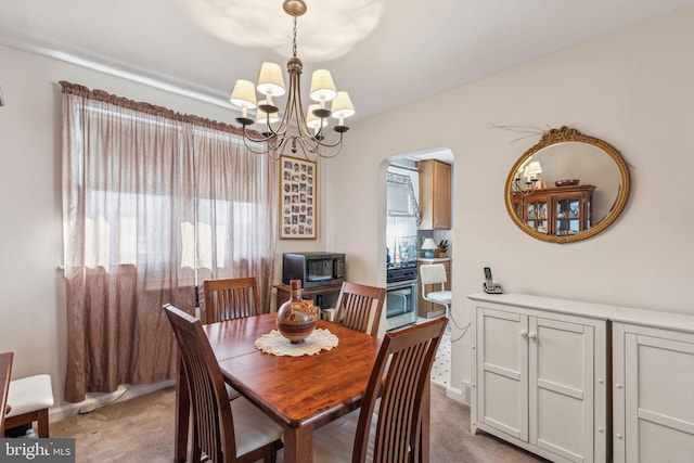 dining area with carpet flooring and a notable chandelier