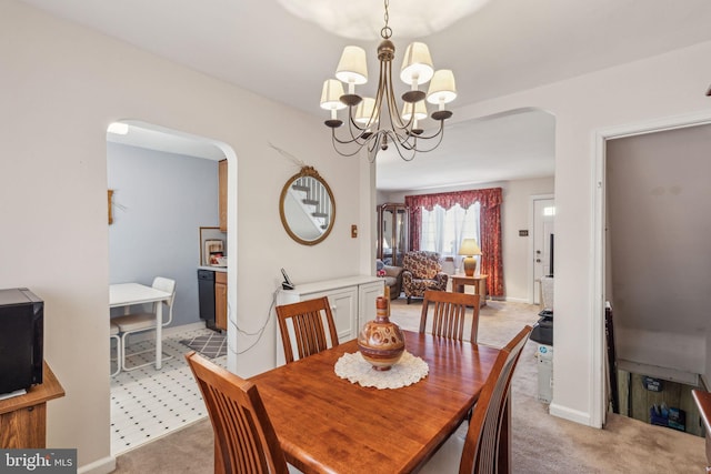 carpeted dining space with an inviting chandelier