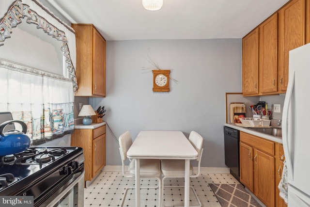 kitchen with sink, stainless steel range with gas cooktop, black dishwasher, and white fridge