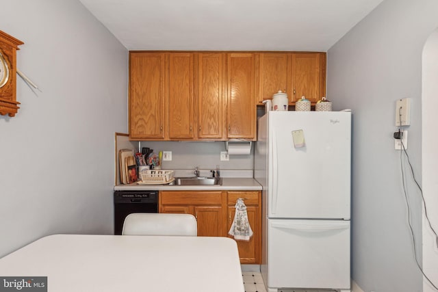 kitchen featuring white refrigerator, dishwasher, and sink