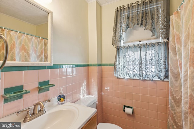 bathroom featuring tile walls, vanity, crown molding, and toilet