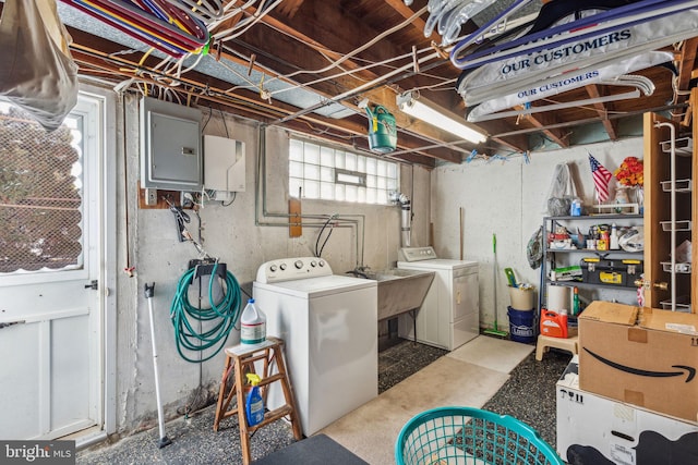 clothes washing area featuring sink, electric panel, and washing machine and dryer