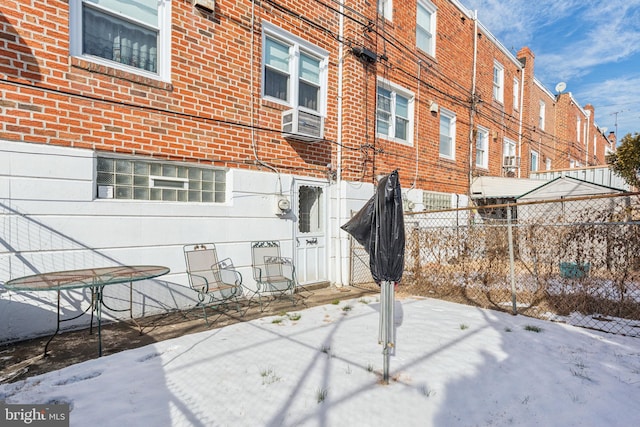 snow covered patio featuring cooling unit