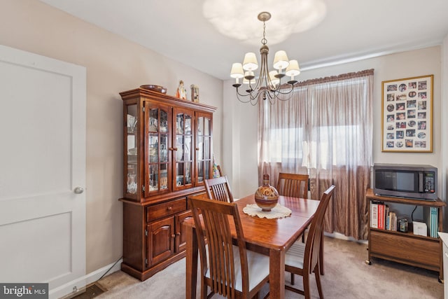 carpeted dining space with a chandelier