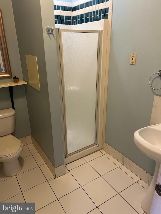 bathroom with tile patterned flooring, an enclosed shower, and toilet