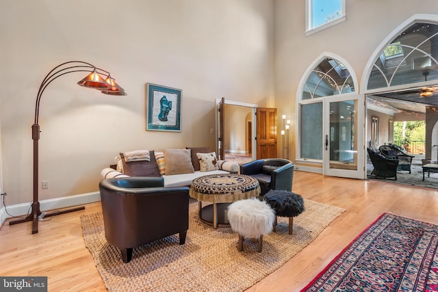 living room featuring a towering ceiling and wood-type flooring