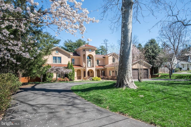 mediterranean / spanish house with a garage and a front yard