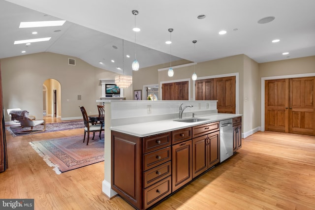 kitchen featuring dishwasher, lofted ceiling, sink, hanging light fixtures, and light hardwood / wood-style floors