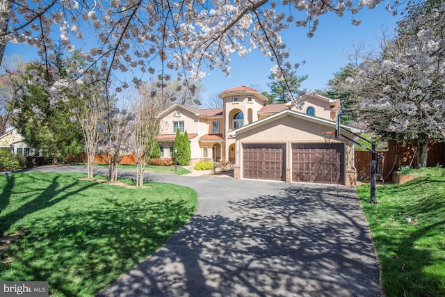 mediterranean / spanish home with a garage and a front yard