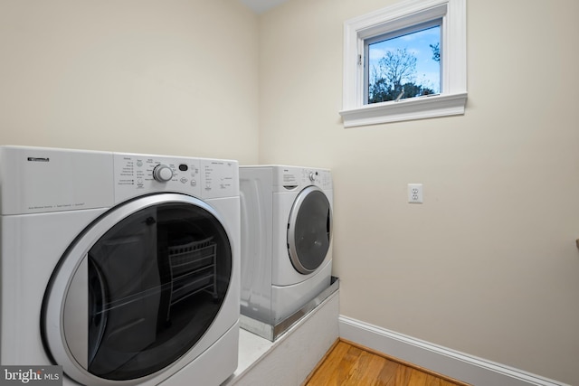 laundry room with light hardwood / wood-style floors and washing machine and dryer