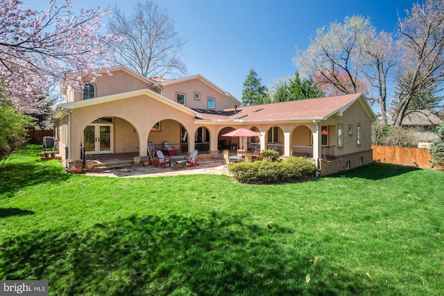 back of property featuring a yard, a patio area, and french doors