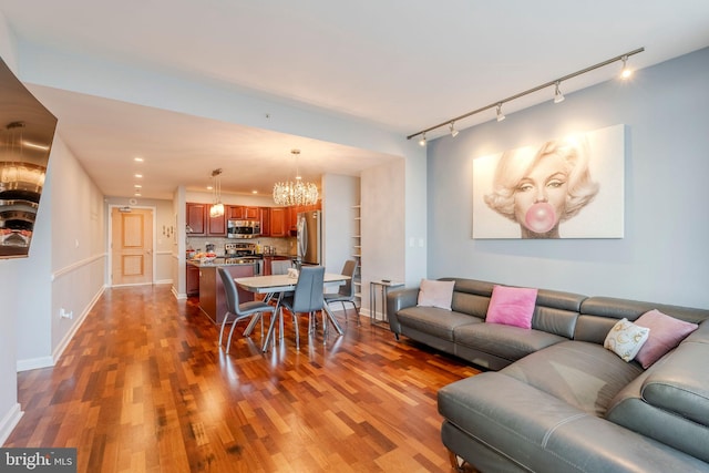 living room featuring an inviting chandelier and hardwood / wood-style floors