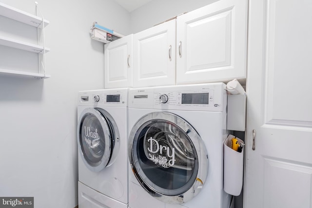 clothes washing area with washer and clothes dryer and cabinets