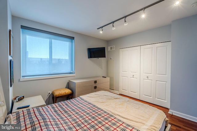 bedroom featuring dark hardwood / wood-style flooring and a closet