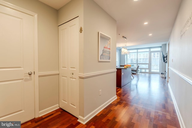 hallway featuring dark hardwood / wood-style flooring and a notable chandelier