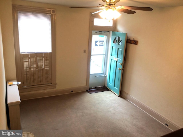 doorway to outside with carpet floors and ceiling fan