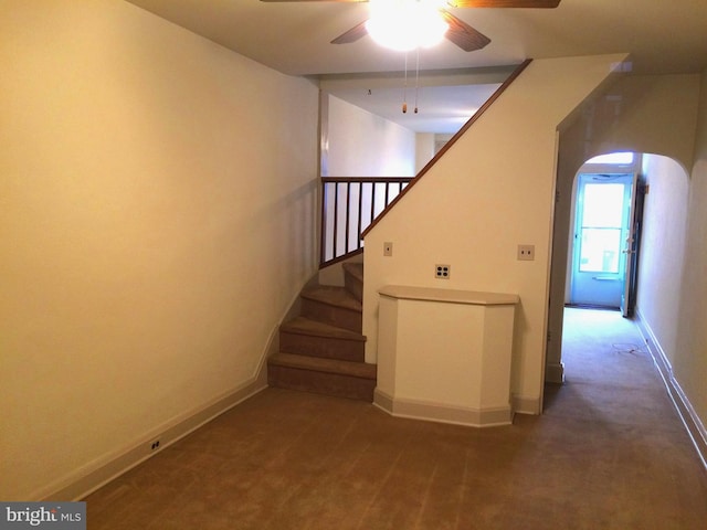 stairs with ceiling fan and carpet flooring