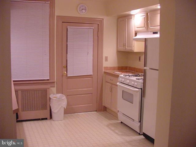 kitchen with white appliances and radiator heating unit