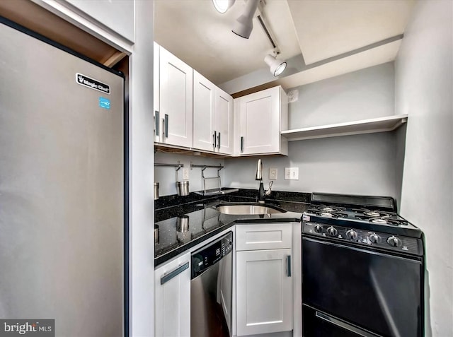 kitchen with appliances with stainless steel finishes, sink, track lighting, and white cabinets