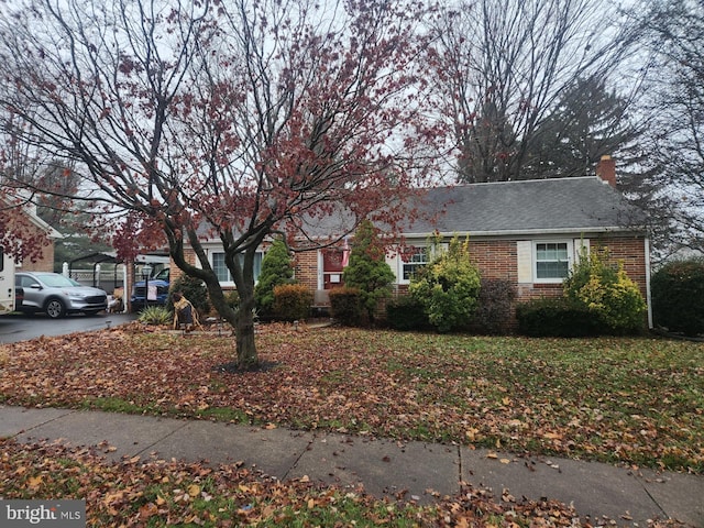 view of front of home featuring brick siding and a chimney