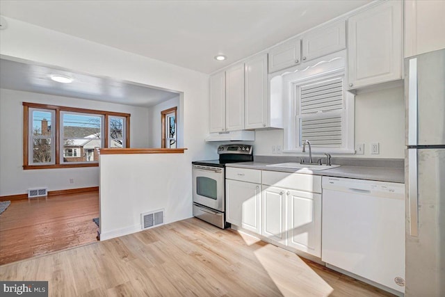 kitchen featuring sink, light hardwood / wood-style flooring, white cabinets, and appliances with stainless steel finishes