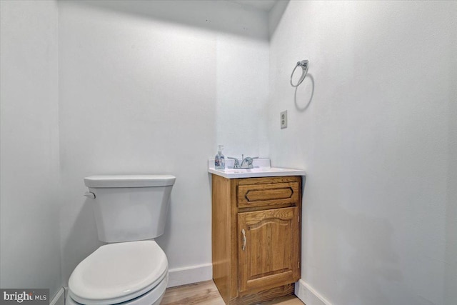 bathroom featuring vanity, hardwood / wood-style floors, and toilet