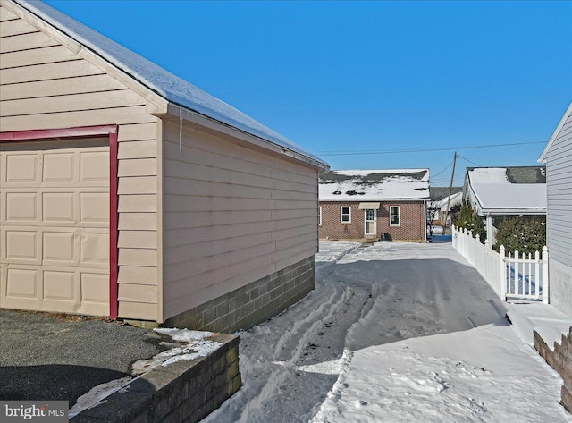 view of snow covered exterior featuring an outbuilding