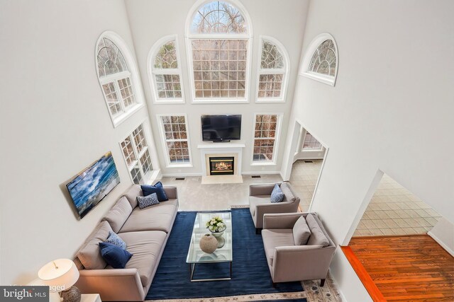 living room featuring a high ceiling and a glass covered fireplace
