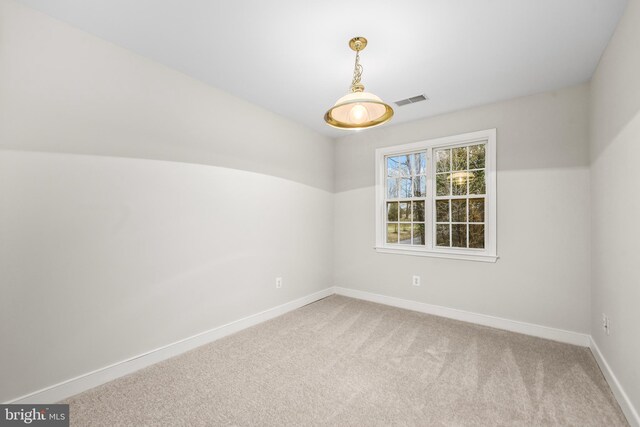 carpeted empty room with visible vents and baseboards