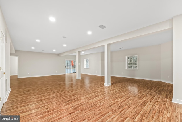 below grade area with recessed lighting, light wood-type flooring, visible vents, and baseboards