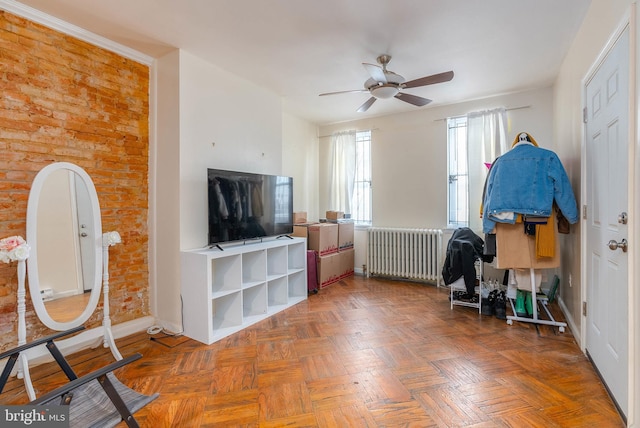 living room featuring ceiling fan, parquet flooring, and radiator