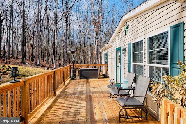 wooden terrace featuring a hot tub