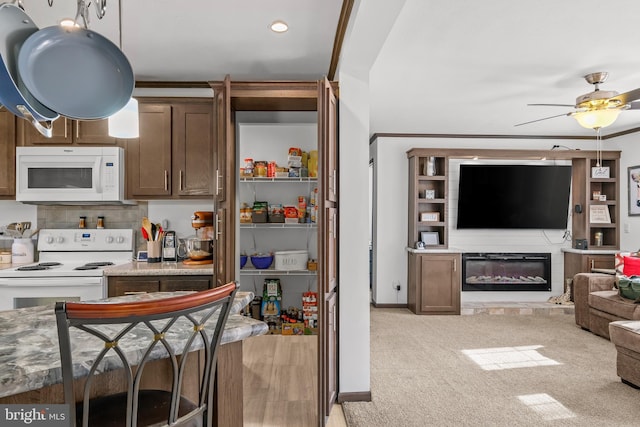 kitchen with ceiling fan, white appliances, and light carpet