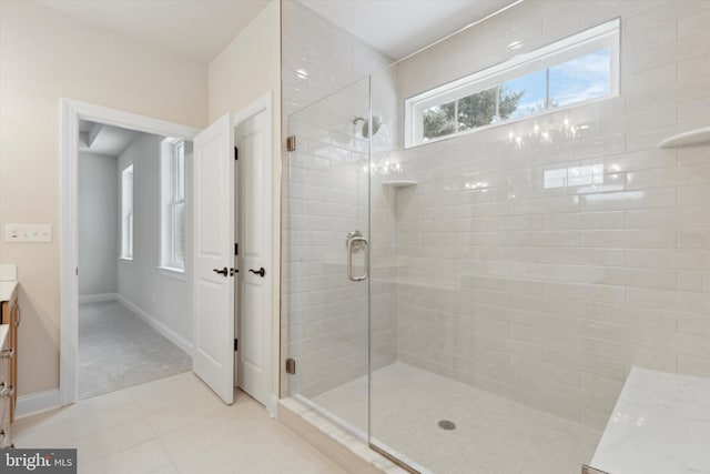 bathroom featuring tile patterned flooring, vanity, plenty of natural light, and walk in shower