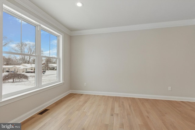 empty room featuring ornamental molding and light hardwood / wood-style floors