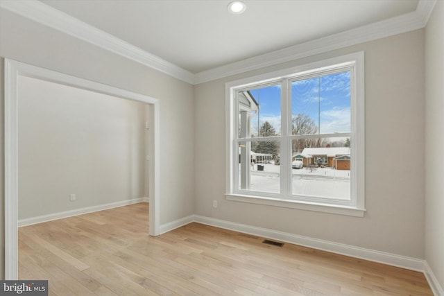 empty room featuring light hardwood / wood-style flooring and ornamental molding