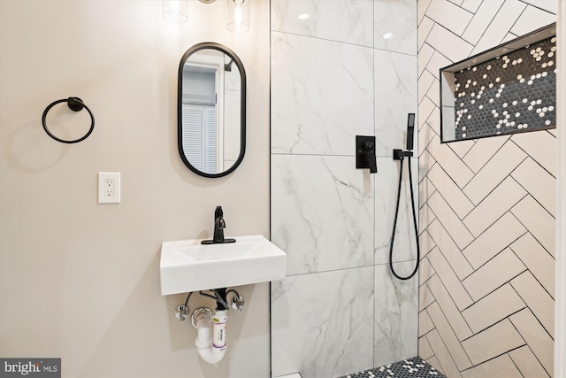 bathroom featuring tiled shower and sink